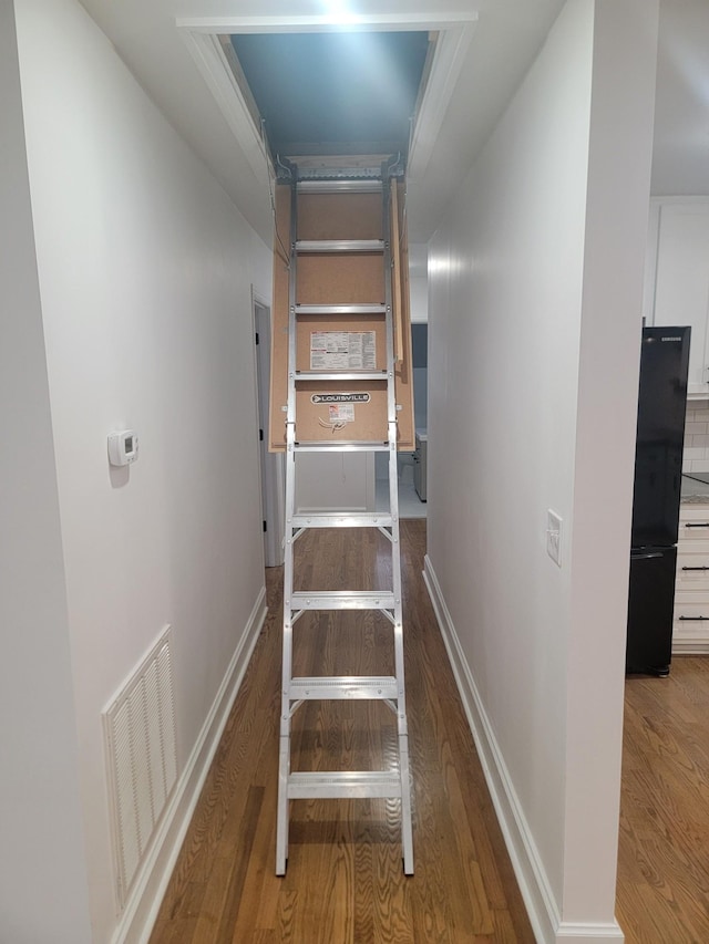 stairway featuring hardwood / wood-style flooring and ornamental molding