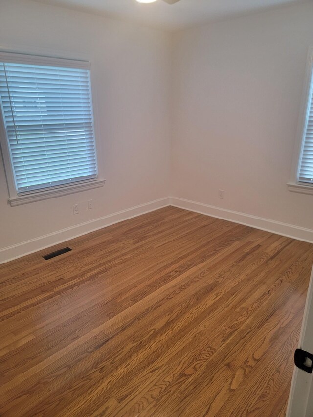 unfurnished room with hardwood / wood-style floors