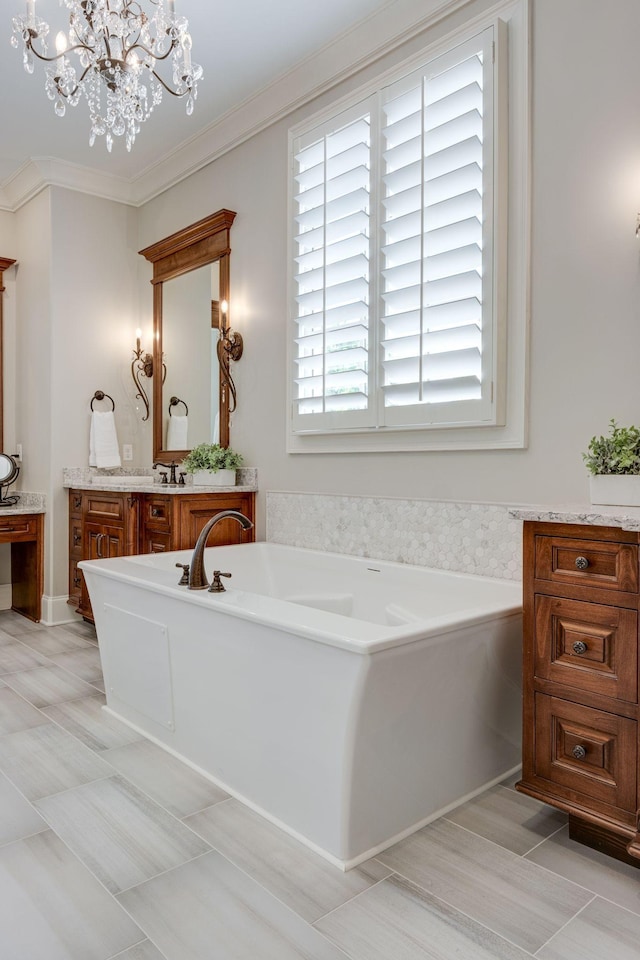 bathroom featuring a bathing tub, an inviting chandelier, tile patterned floors, crown molding, and vanity