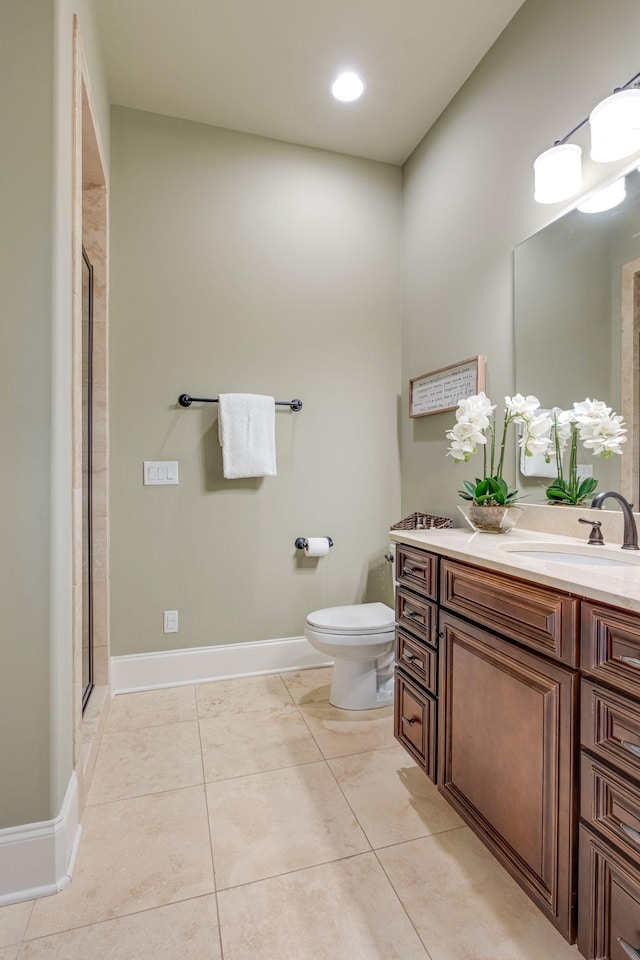 bathroom featuring tile patterned flooring, vanity, toilet, and walk in shower