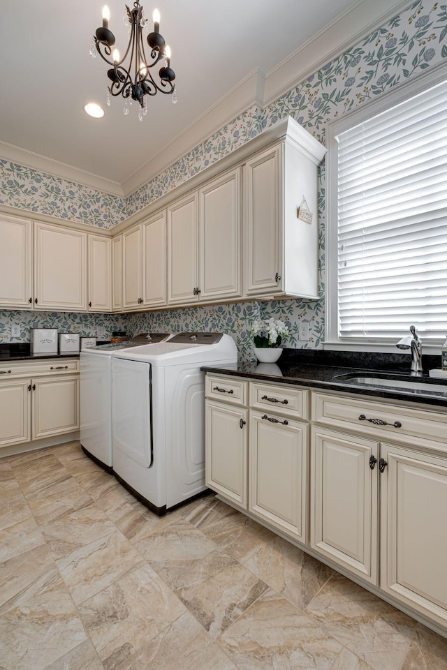 washroom featuring cabinets, ornamental molding, sink, a notable chandelier, and washing machine and dryer