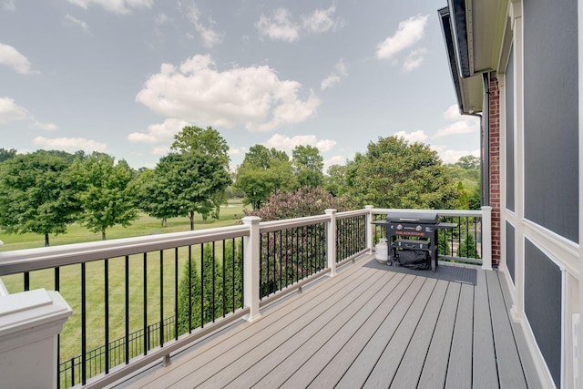 wooden terrace with area for grilling and a yard