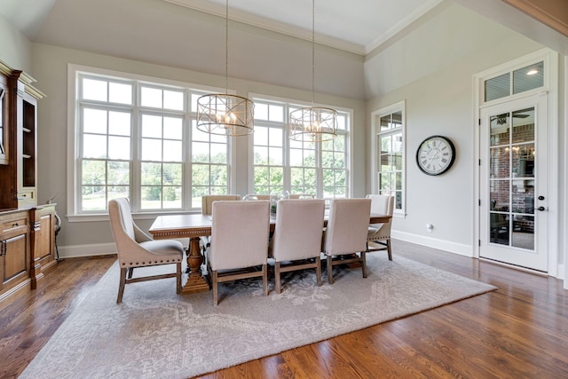 dining room with dark hardwood / wood-style floors, an inviting chandelier, and crown molding