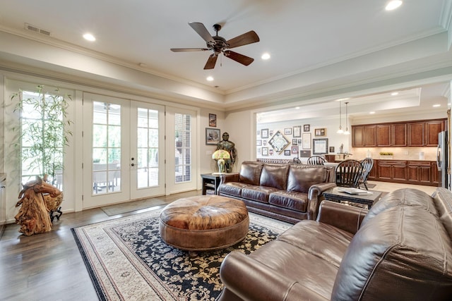 living room with french doors, a raised ceiling, ceiling fan, and crown molding