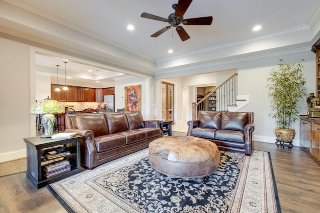 living room featuring dark hardwood / wood-style flooring, a raised ceiling, ceiling fan, and crown molding