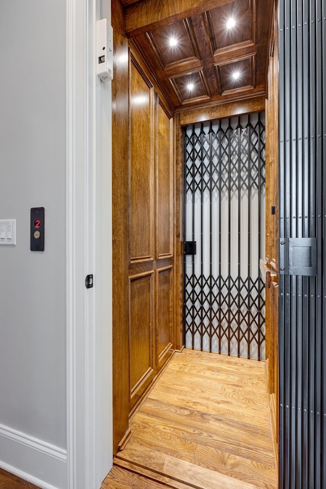 interior space featuring coffered ceiling, beamed ceiling, wood walls, crown molding, and wood ceiling