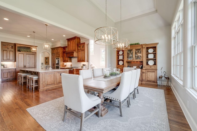 dining space featuring a chandelier, hardwood / wood-style flooring, plenty of natural light, and ornamental molding