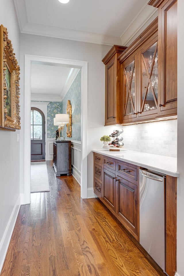 bar featuring dishwasher, wood-type flooring, and crown molding