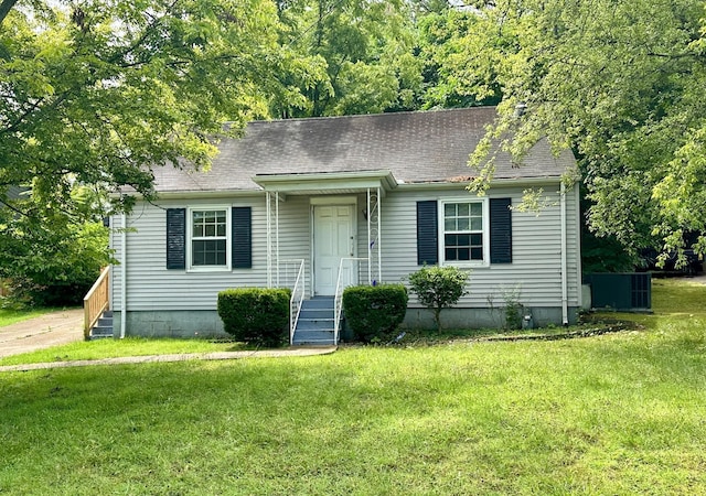 view of front of property featuring a shingled roof, a front lawn, and cooling unit