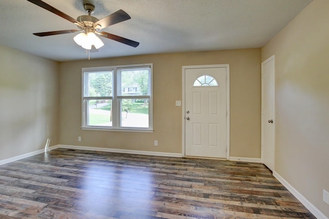 entrance foyer with ceiling fan, dark wood-type flooring, and a textured ceiling