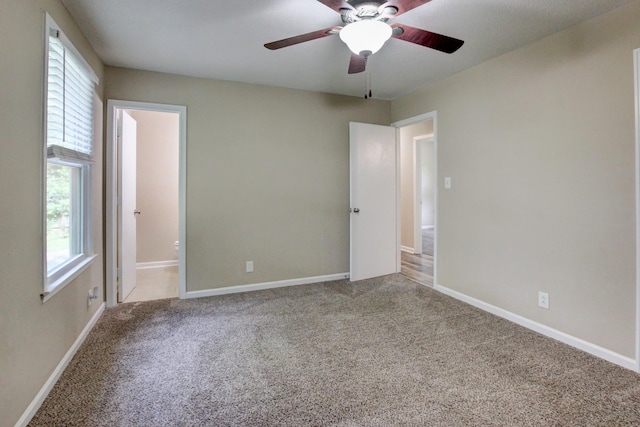 spare room with a wealth of natural light, ceiling fan, and carpet