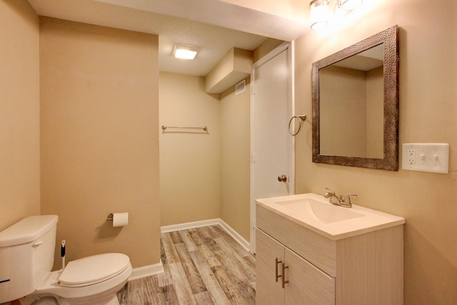 bathroom featuring hardwood / wood-style floors, vanity, and toilet