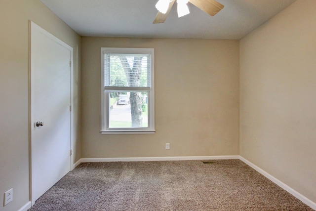 carpeted spare room featuring ceiling fan