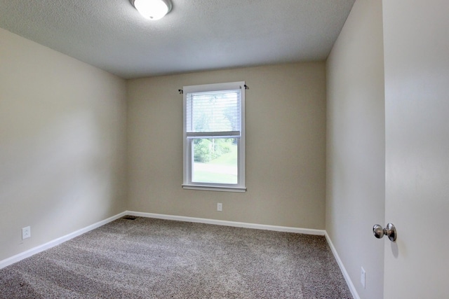 carpeted empty room with a textured ceiling