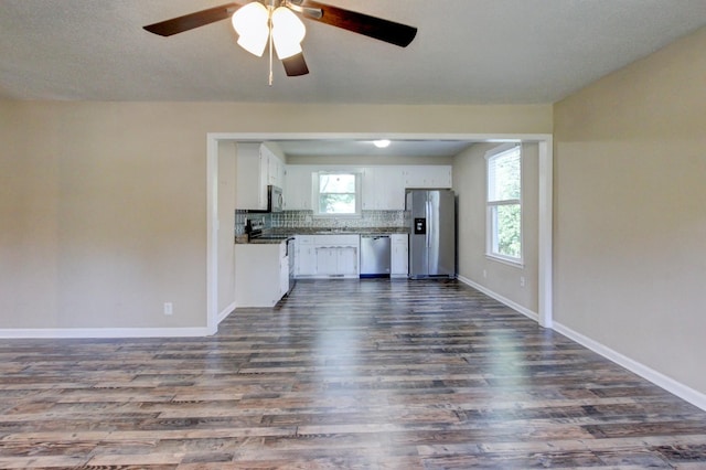 unfurnished living room with dark hardwood / wood-style floors, plenty of natural light, and ceiling fan