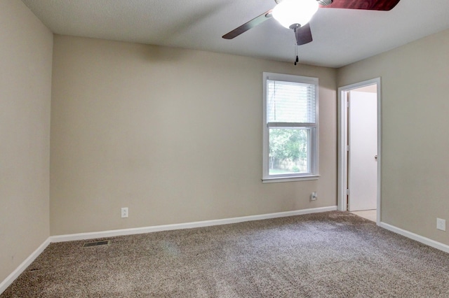 carpeted spare room featuring ceiling fan