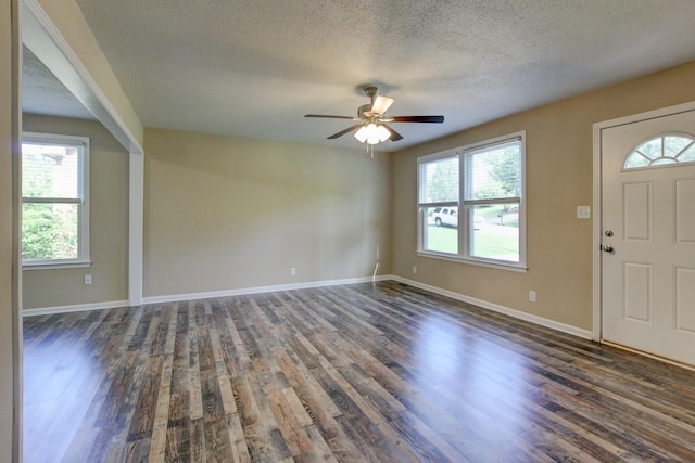 foyer entrance featuring dark hardwood / wood-style floors, ceiling fan, a textured ceiling, and a wealth of natural light