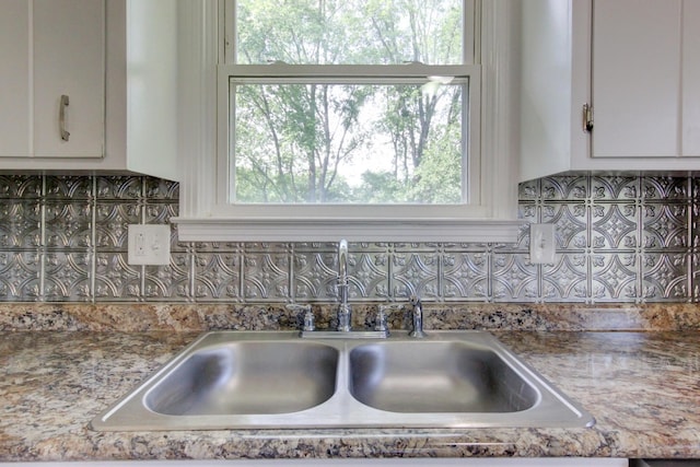 kitchen featuring white cabinets, plenty of natural light, sink, and tasteful backsplash