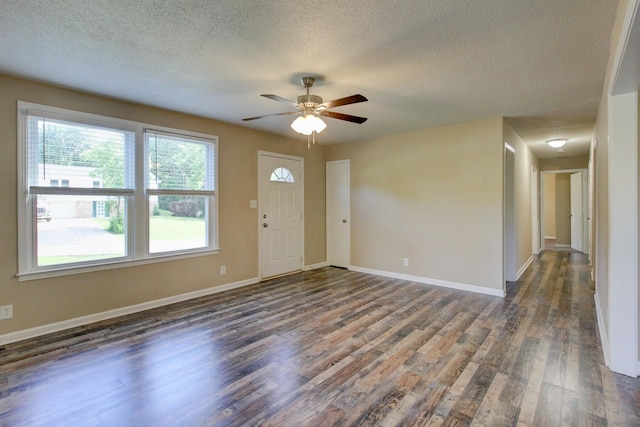 interior space featuring ceiling fan, dark wood-type flooring, and a textured ceiling