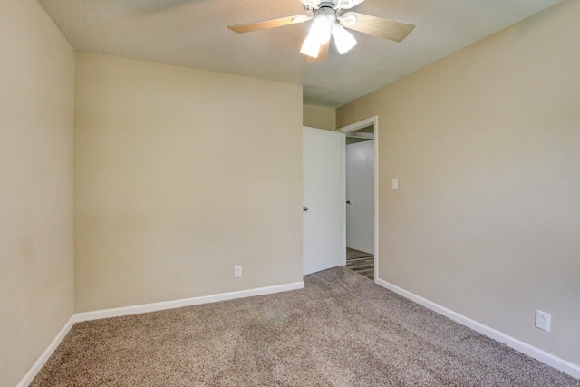 carpeted spare room featuring ceiling fan