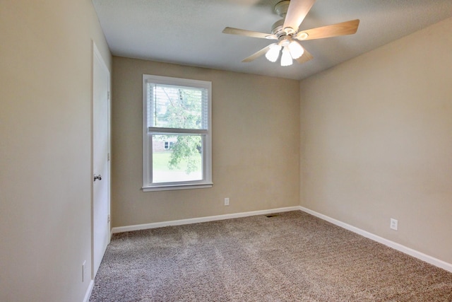 carpeted spare room featuring ceiling fan