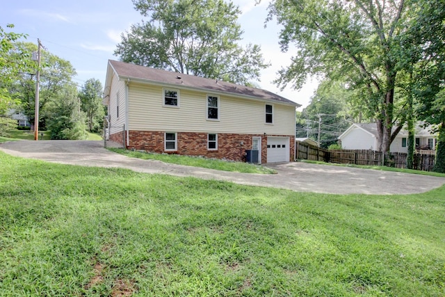 view of side of home featuring a lawn, central AC unit, and a garage