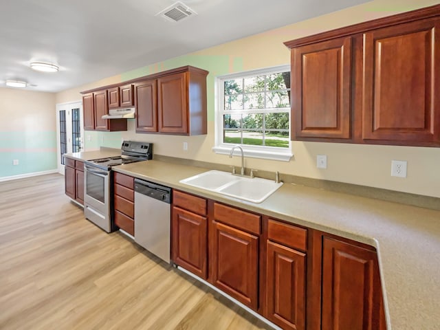 kitchen featuring stainless steel appliances, light hardwood / wood-style floors, and sink