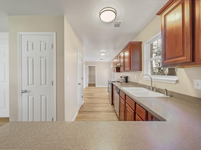 kitchen featuring stainless steel appliances, light hardwood / wood-style floors, and sink