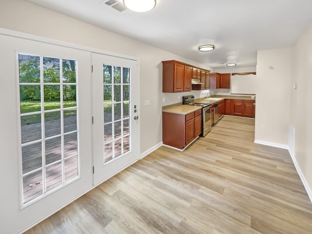 kitchen featuring a healthy amount of sunlight, light hardwood / wood-style flooring, and stainless steel range with electric cooktop