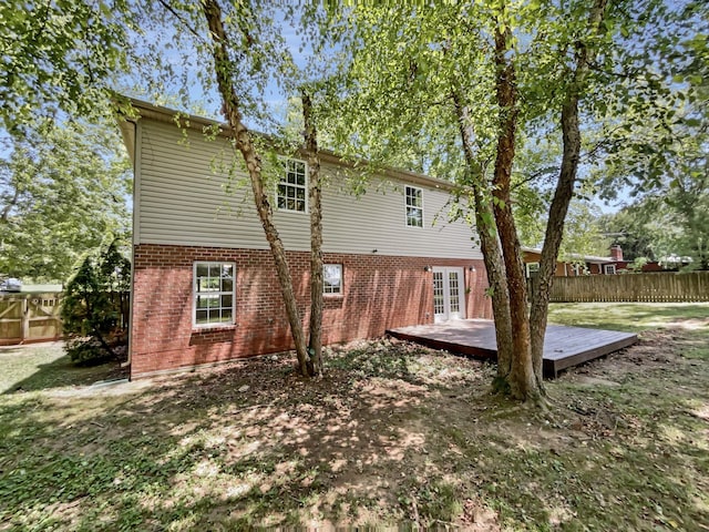 rear view of property with a wooden deck and french doors