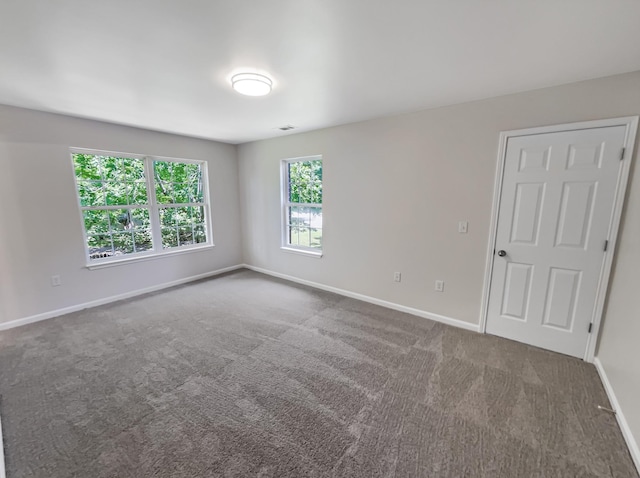 spare room featuring dark carpet