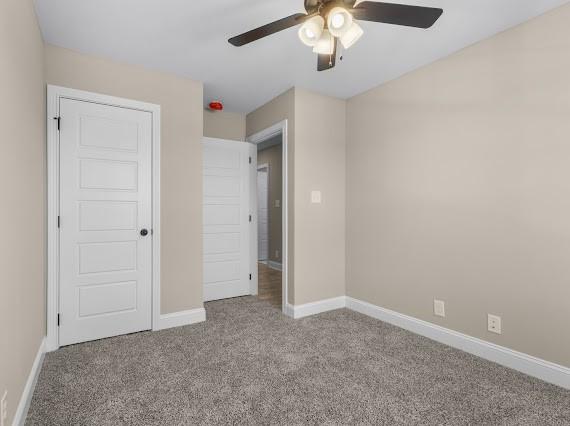 unfurnished bedroom featuring ceiling fan and light colored carpet