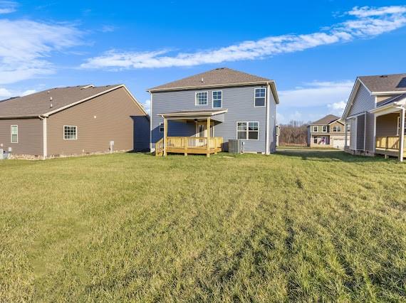 back of house with a deck and a lawn