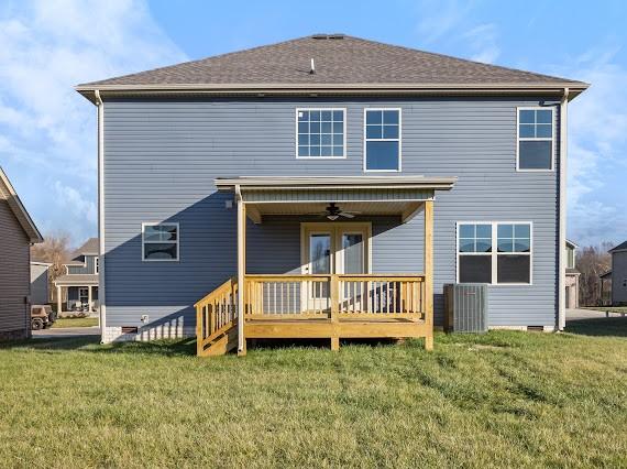 back of house featuring ceiling fan, a deck, and a lawn