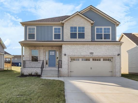 view of front of house with a garage, a porch, and a front lawn