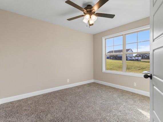 carpeted spare room with ceiling fan