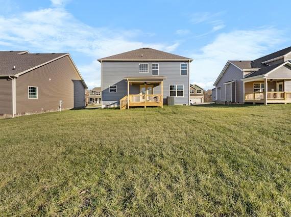 rear view of property with a deck and a lawn