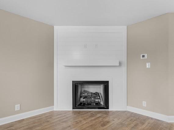 details with wood-type flooring and a large fireplace