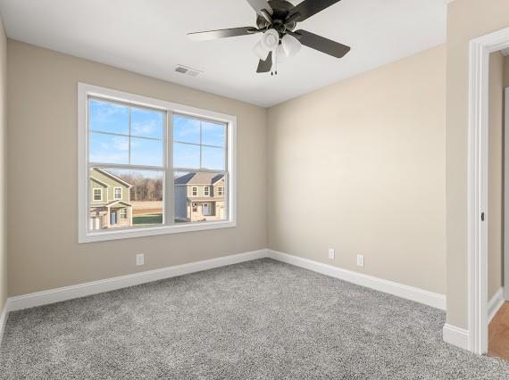 carpeted spare room featuring ceiling fan