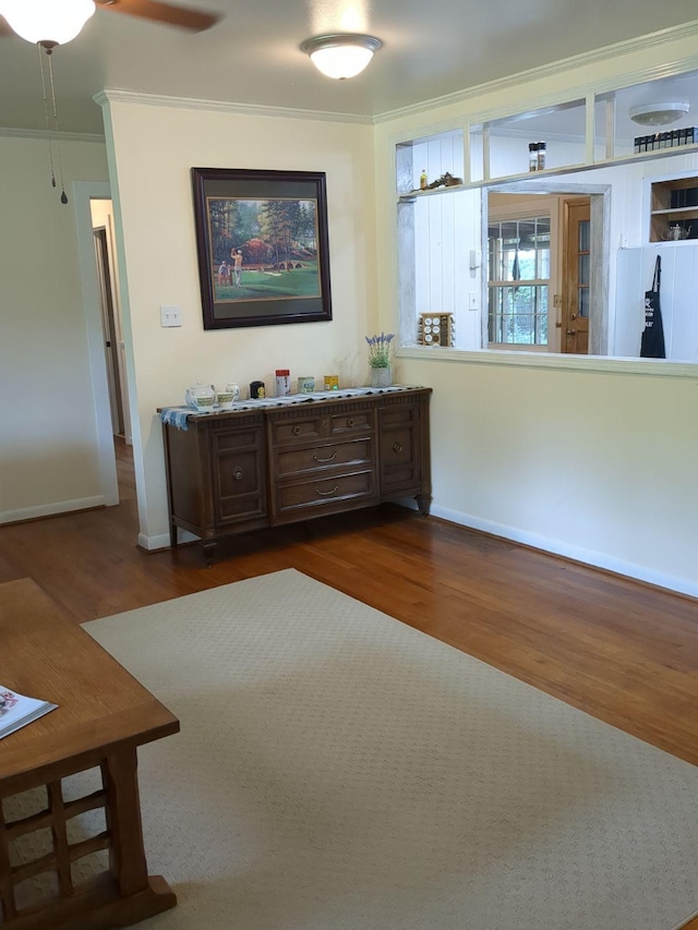 unfurnished living room with ceiling fan, crown molding, and dark wood-type flooring