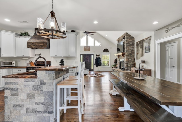 1033 Carter Rd SE, Old Fort, TN 37362 - kitchen featuring a kitchen breakfast bar, dark hardwood / wood-style floors, white cabinets, a stone fireplace, and decorative light fixtures