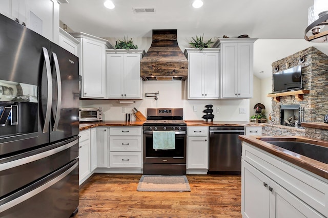 1033 Carter Rd SE, Old Fort, TN 37362 - kitchen featuring stainless steel appliances, premium range hood, and white cabinetry