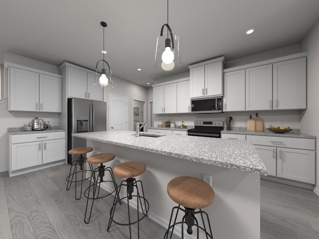 kitchen featuring decorative light fixtures, white cabinetry, sink, a kitchen island with sink, and stainless steel appliances