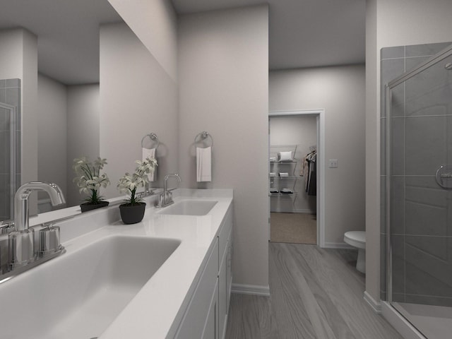 bathroom featuring vanity, hardwood / wood-style flooring, a shower with shower door, and toilet