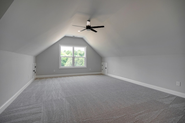 additional living space with ceiling fan, lofted ceiling, and light carpet