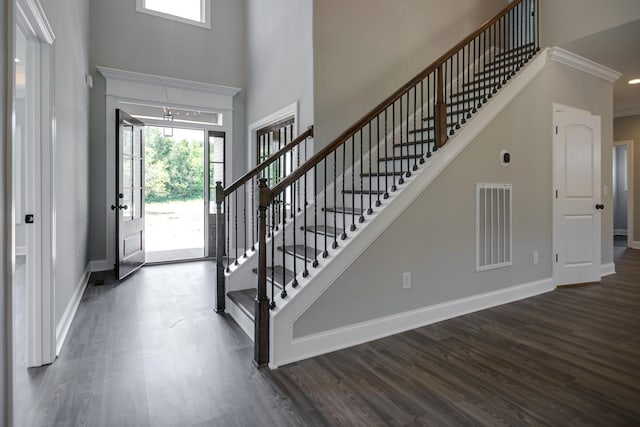 entrance foyer with dark hardwood / wood-style floors and ornamental molding