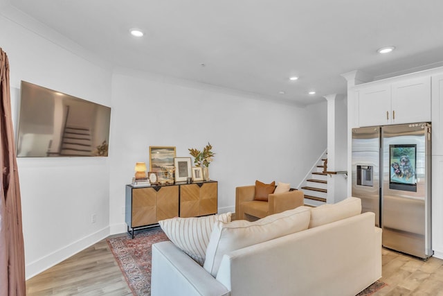 living room featuring light hardwood / wood-style flooring and crown molding