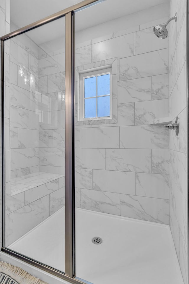 bathroom featuring a shower with shower door