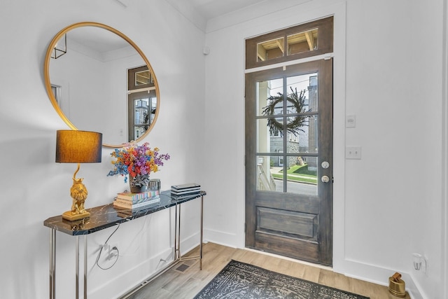 entryway featuring crown molding and light hardwood / wood-style floors