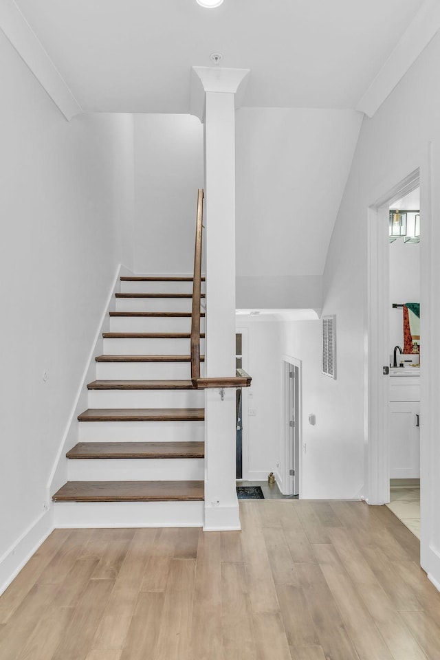 staircase featuring sink and wood-type flooring